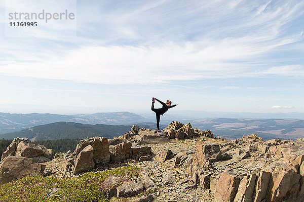 Junge Frau auf Felsen stehend  in Yogastellung  Silver Star Mountain  Washington  USA