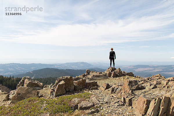 Junge Frau steht auf Fels und schaut auf Aussicht  Silver Star Mountain  Washington  USA