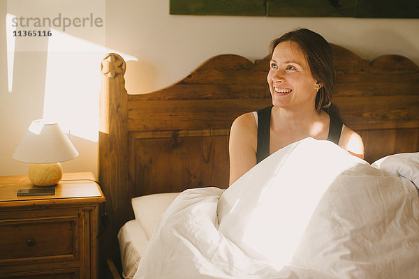 Lächelnde Frau im Bett