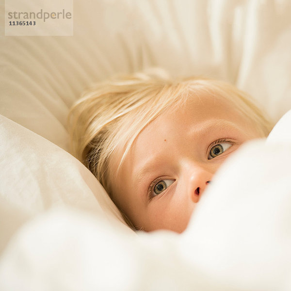Bildnis eines blondhaarigen Jungen im Bett