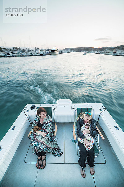 Frauen mit Hund und Babymädchen in Decken gehüllt auf einem Boot  Dana Point  Kalifornien  USA