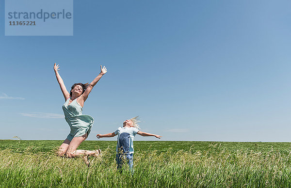 Mutter und Sohn springen vor Freude im Feld