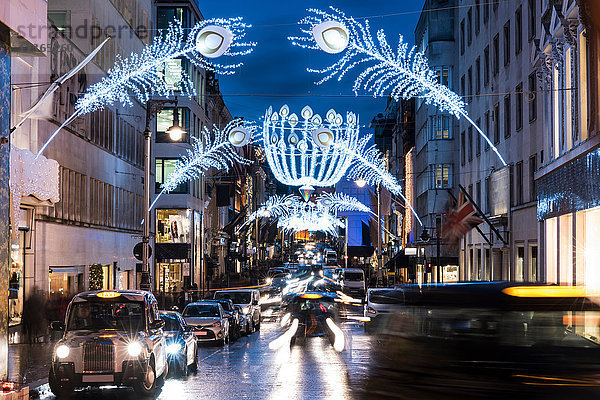 Weihnachtsbeleuchtung und Verkehr auf der City Street in der Abenddämmerung  London  UK