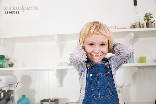 Porträt eines jungen Mädchens in der Küche  Hände hinter dem Kopf  lächelnd