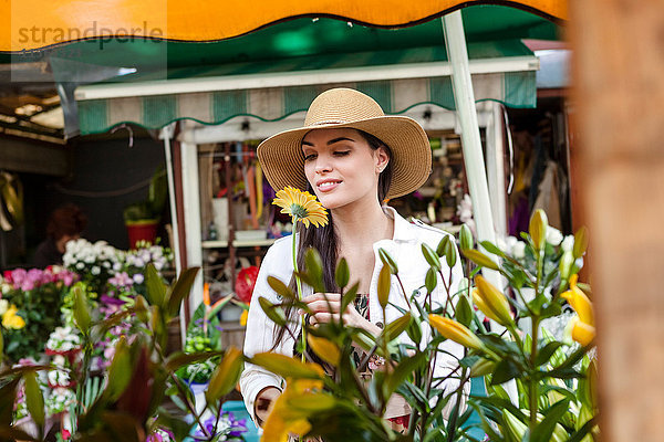 Junge weibliche Touristin riecht Blumen am Marktstand  Split  Dalmatien  Kroatien