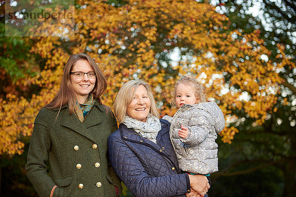 Porträt einer älteren Frau mit Tochter und Enkelin im Herbstpark