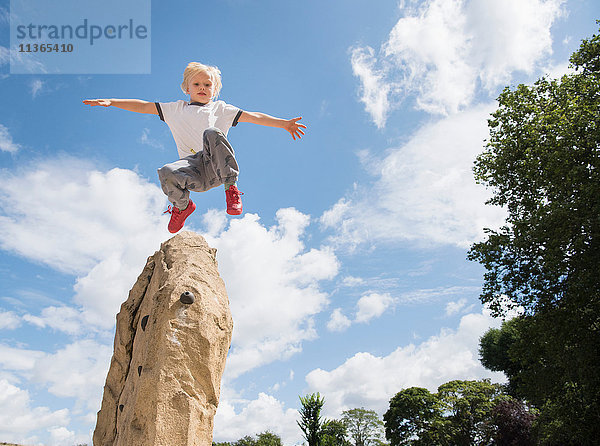 Junge springt vom Felsen