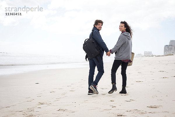 Porträt eines jungen Paares bei einem Strandspaziergang in der Rückansicht  Western Cape  Südafrika