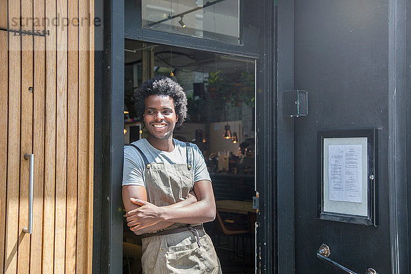 Porträt des Kellners in der Tür des städtischen Straßencafés