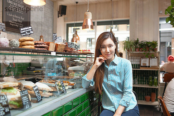 Porträt der mittleren erwachsenen Frau im Café
