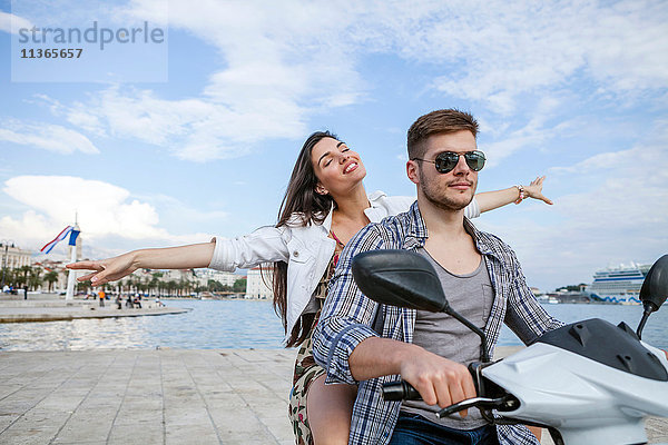 Junges Paar beim Mopedfahren im Hafen  Split  Dalmatien  Kroatien
