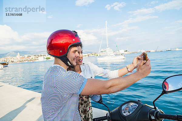 Junges Mopedpaar beim Selbstfahren im Hafen  Split  Dalmatien  Kroatien