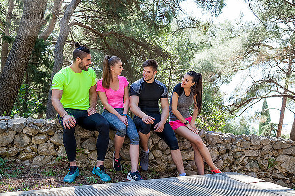 Vier Läufer und Läuferinnen unterhalten sich an der Parkwand  Split  Dalmatien  Kroatien