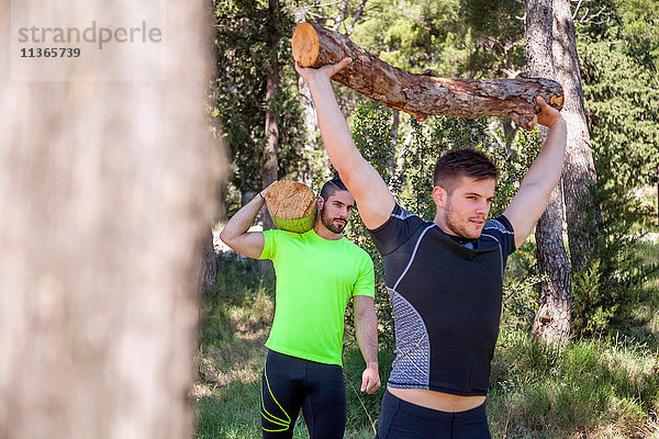 Zwei junge Männer machen Gewichthebertraining mit Baumstämmen im Wald  Split  Dalmatien  Kroatien