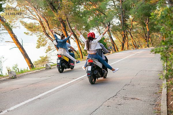 Rückansicht von zwei Moped fahrenden Paaren auf einer Landstraße  Split  Dalmatien  Kroatien