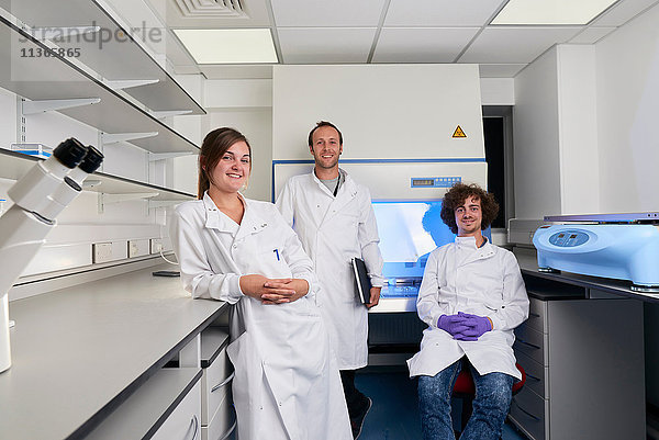 Wissenschaftler im Labor schauen lächelnd in die Kamera