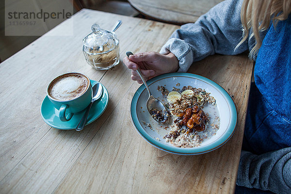 Junge Frau im Cafe  Müsli essen  Mittelteil