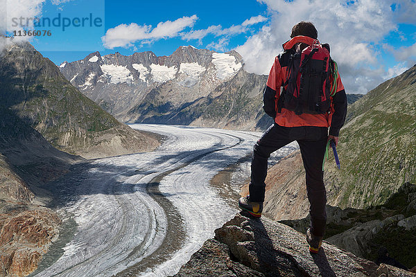 Rückansicht eines einsamen männlichen Bergsteigers mit Blick auf den Aletschgletscher  Kanton Wallis  Schweiz