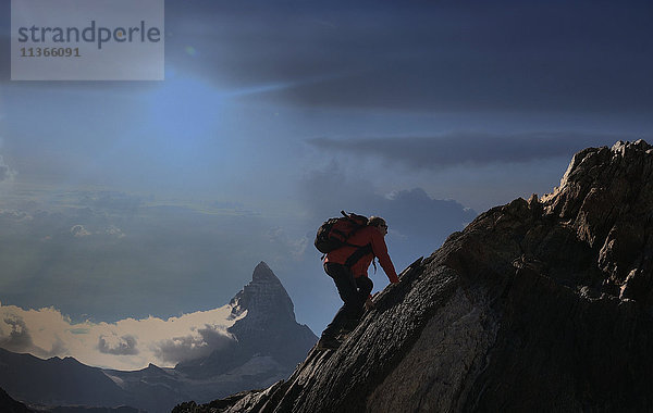 Älterer männlicher Bergsteiger klettert an einer Felswand in der Nähe des Matterhorns  Kanton Wallis  Schweiz