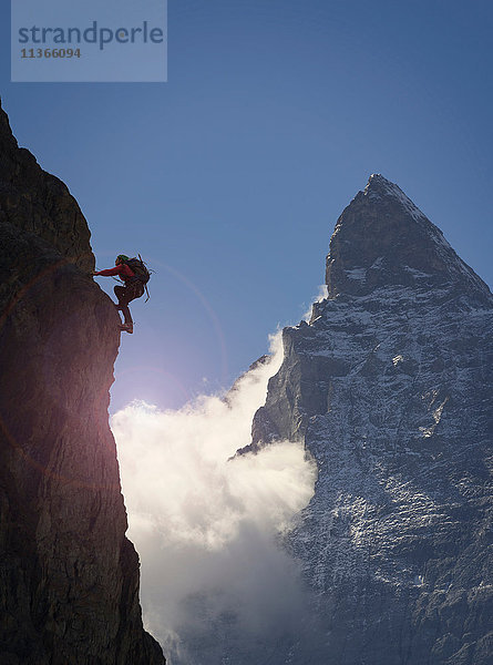 Silhouette einer Bergsteigerin beim Klettern an einer Felswand in der Nähe des Matterhorns  Kanton Wallis  Schweiz