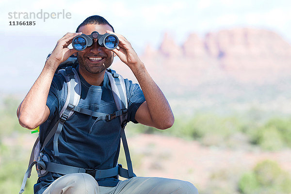 Porträt eines jungen Mannes  der durch ein Fernglas schaut  Sedona  Arizona  USA