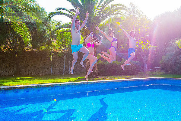 Freunde springen gemeinsam ins Schwimmbad