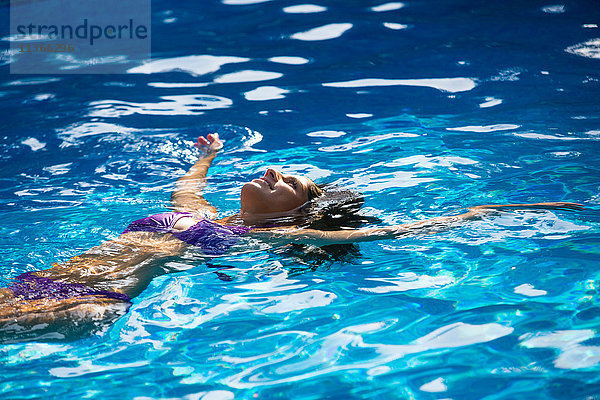 Frau beim Rückenschwimmen im Schwimmbad