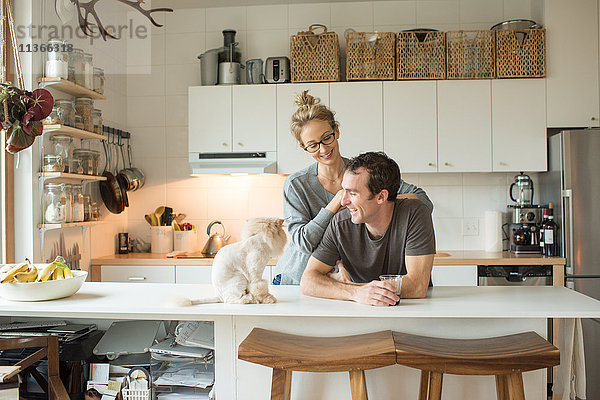Mittleres erwachsenes Paar mit Katze am Küchentisch