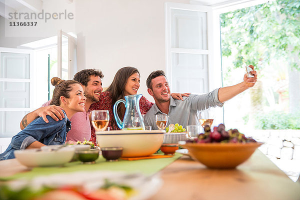 Freunde essen zusammen  nehmen ein Selfie