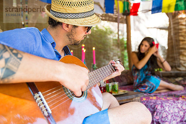 Mann spielt Gitarre und bringt der Frau ein Ständchen