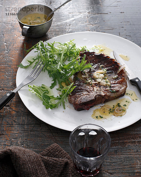 Bistro-Menü mit T-Bone-Steak mit Beerensauce und Rotwein auf dem Tisch