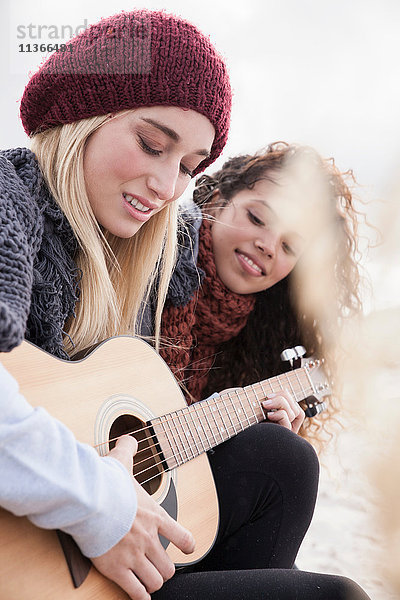 Zwei junge Frauen spielen Gitarre am Strand  Western Cape  Südafrika