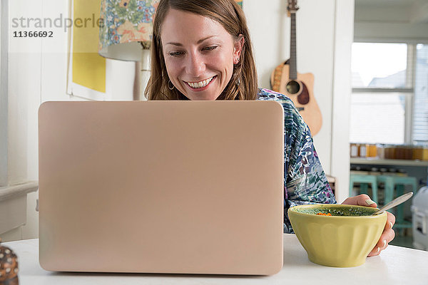 Frau mit Laptop lächelt