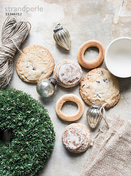 Draufsicht auf silberne Weihnachtskugeln und frische Kekse und Bagels