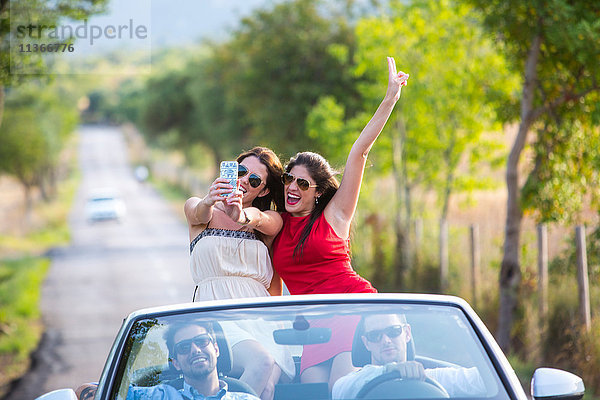 Zwei junge Freundinnen beim Selfie-Fahren auf der Landstraße im Cabriolet  Mallorca  Spanien