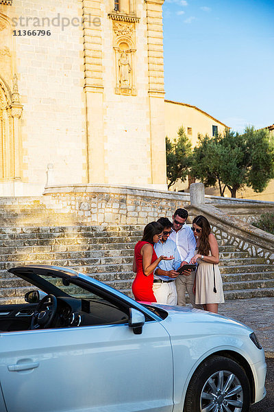Zwei Touristenpaare schauen sich ein digitales Tablet in der Kirche an  Calvia  Mallorca  Spanien