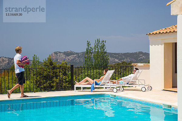 Kellner mit Handtüchern für ein Gästepaar am Swimmingpool eines Boutique-Hotels  Mallorca  Spanien