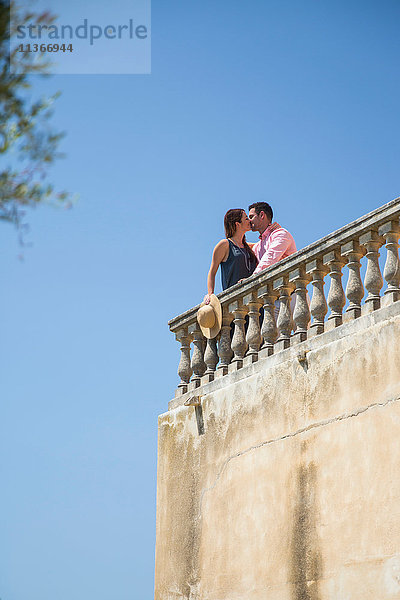 Ein Paar küsst sich auf dem Dachbalkon eines Boutique-Hotels  Mallorca  Spanien