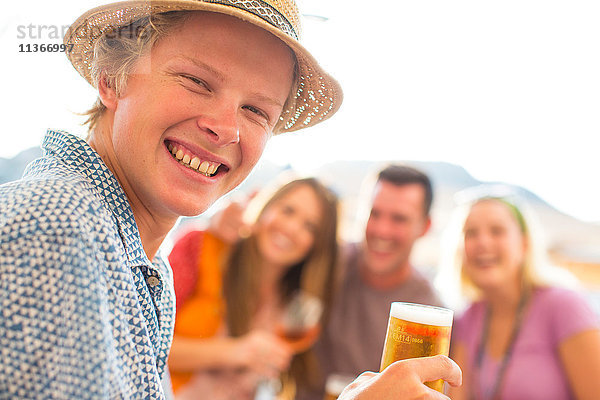 Porträt eines jungen Mannes mit erwachsenen Freunden in einem Restaurant am Wasser  Mallorca  Spanien