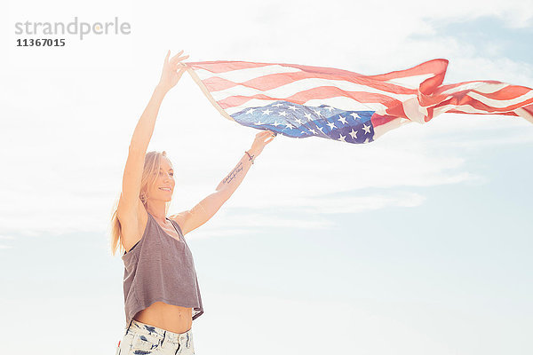 Frau mit erhobenen Armen und amerikanischer Flagge