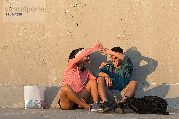 Paar spielt vor einer Betonmauer