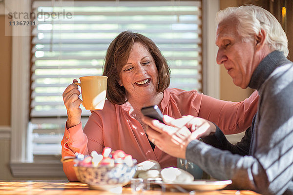 Seniorenpaar sucht Smartphone-Update am Küchentisch