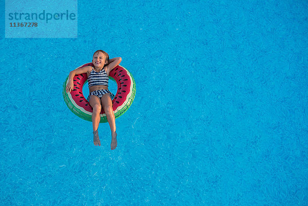 Junges Mädchen im Schwimmbad  entspannt auf aufblasbarem Ring
