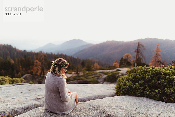 Rückansicht einer Frau  die auf Felsen in den Bergen sitzt  Sequoia-Nationalpark  Kalifornien  USA