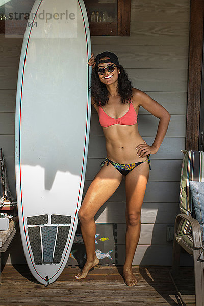 Porträt einer jungen Surferin auf der Veranda stehend  Rockaway Beach  Bundesstaat New York  USA