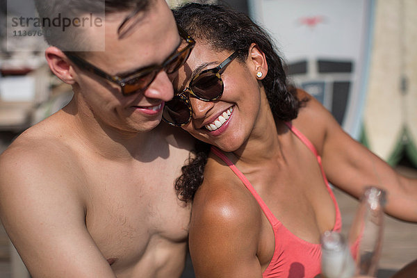 Romantisches junges Paar mit Bierflaschen auf der Veranda  Rockaway Beach  Bundesstaat New York  USA
