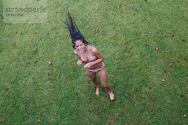 Portrait einer jungen Frau  die lange nasse Haare auf den Rasen zurückwirft  Santa Rosa Beach  Florida  USA