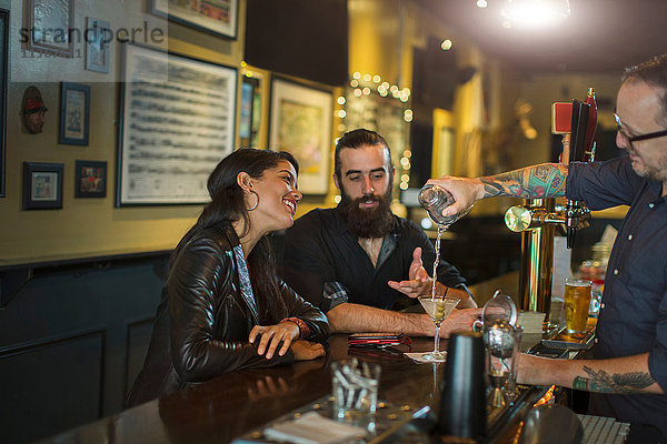 Barkeeper schenkt Cocktail für junges Paar in einer Gaststätte ein