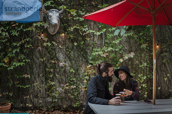 Junges Paar plaudert abends im Biergarten  Brooklyn  New York  USA