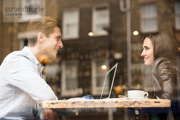 Junger Geschäftsmann und junge Frau mit Laptop im Cafe